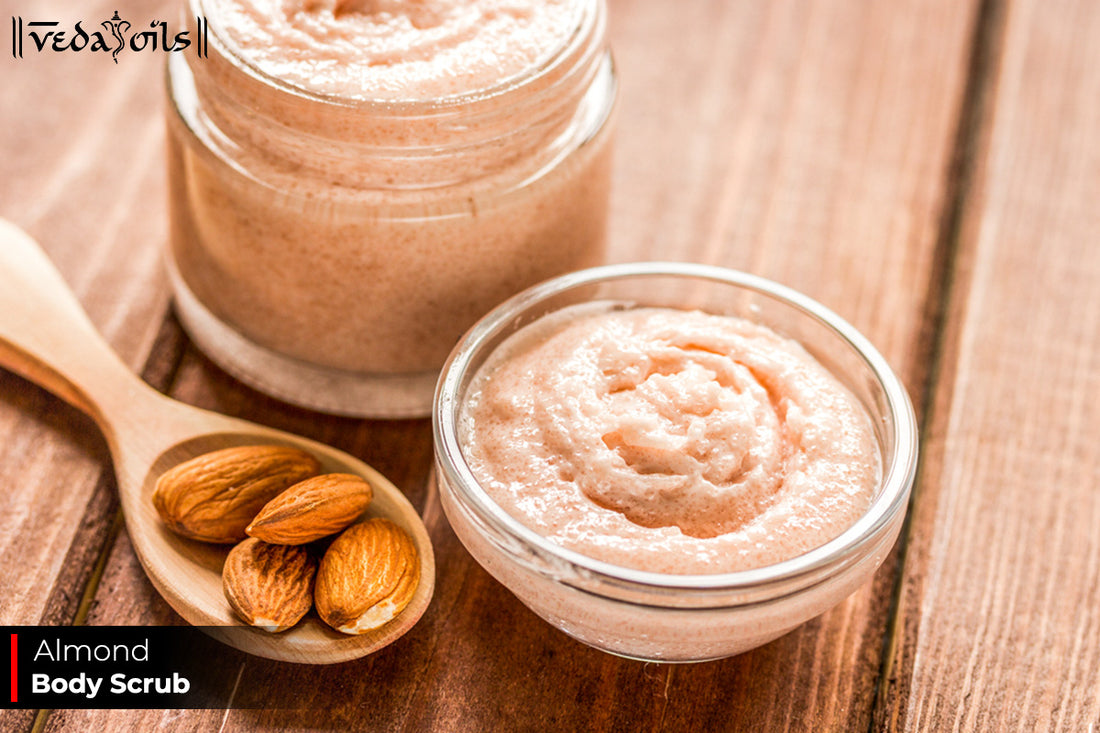 Two jars and a bowl of honey almond body scrub are displayed on a wooden surface. Text reads "Almond Body Scrub".